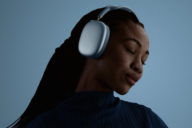 A person listening with blue AirPods Max 2 outdoors