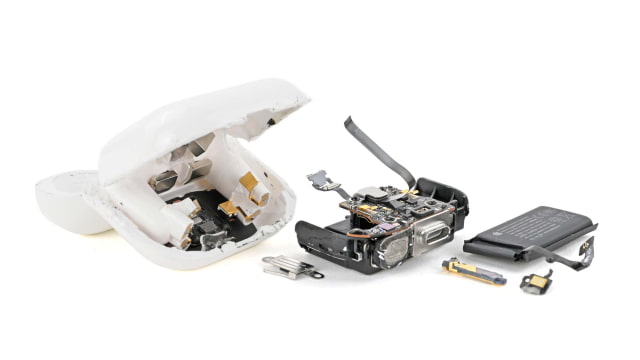 Broken-open white charging case with circuit board and black pouch battery laid beside it