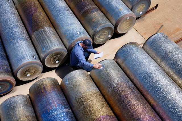 A Perryman Company worker checking titanium stock.