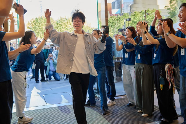 Apple Jing'an team members welcome a customer on iPhone Duo launch day.