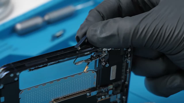 Phone Repair Guru removing the Touch ID button from the iPhone Duo frame.