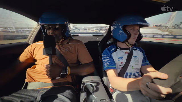 Vince Young holds a microphone in the passenger seat as Liam Lawson drives a Mustang around Circuit of The Americas.
